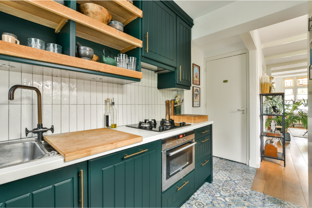 Kitchen with dark green cabinets, open wood shelving and white tile