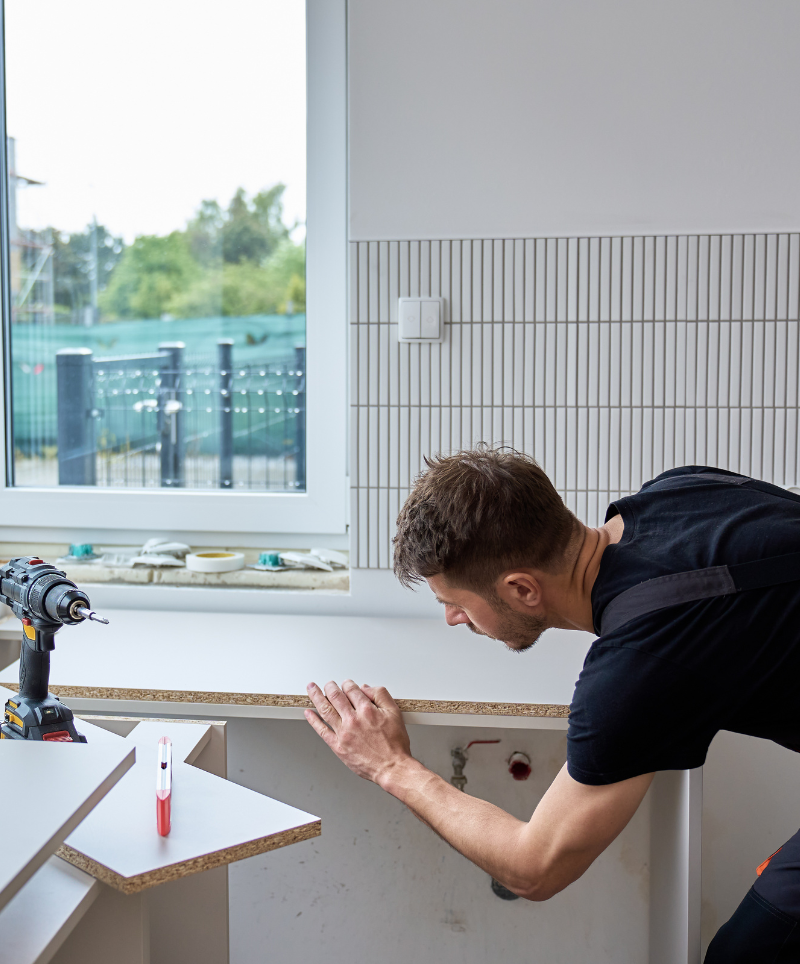 Kitchen designer installing cabinetry during a remodel