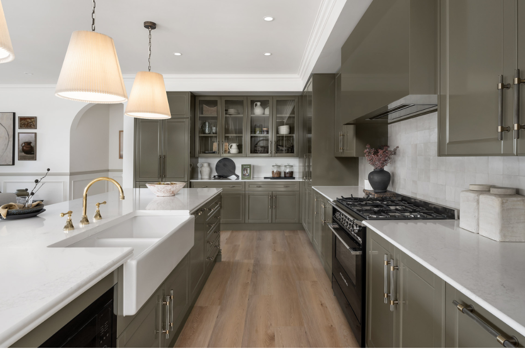 Kitchen remodel with sage green cabinets, farmhouse sink and hardwood floors